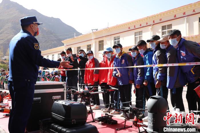 圖為消防指戰(zhàn)員為學(xué)生講解、演示先進(jìn)救援裝備?！≮w琳 攝