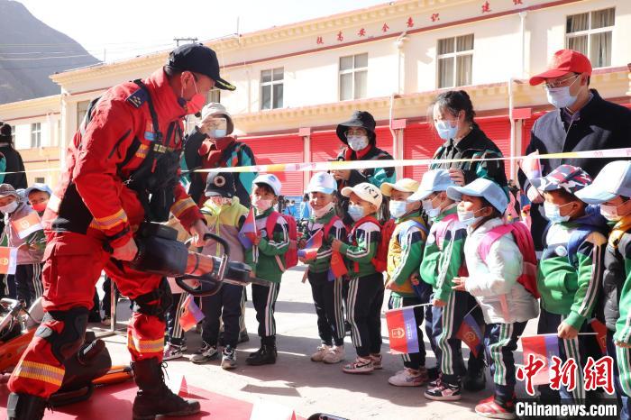 圖為消防指戰(zhàn)員為學(xué)生講解、演示先進(jìn)救援裝備。　趙琳 攝