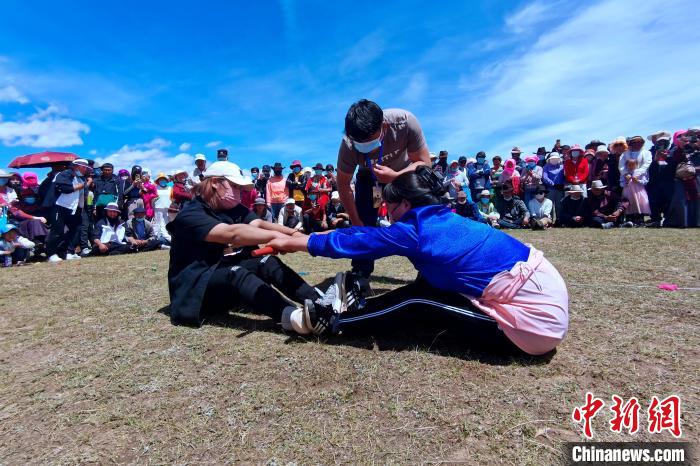 圖為當(dāng)?shù)孛癖娺M(jìn)行蹬棍比賽?！±铍h 攝