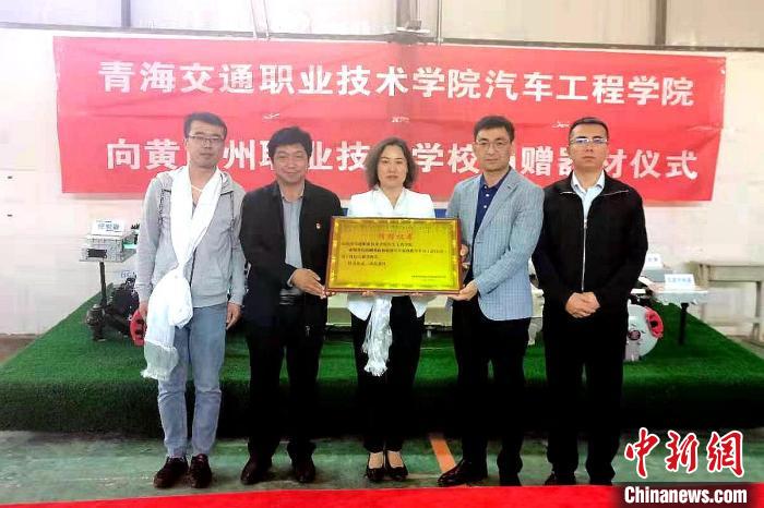 圖為李富香(中)代表學校為州縣技校捐贈器材。(資料圖) 青海省教育廳供圖