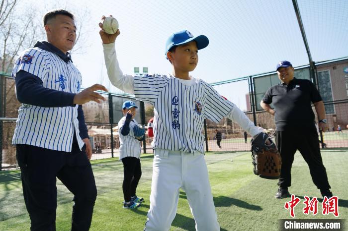 圖為教練指導(dǎo)小棒球手?jǐn)S球技術(shù)。　馬銘言 攝