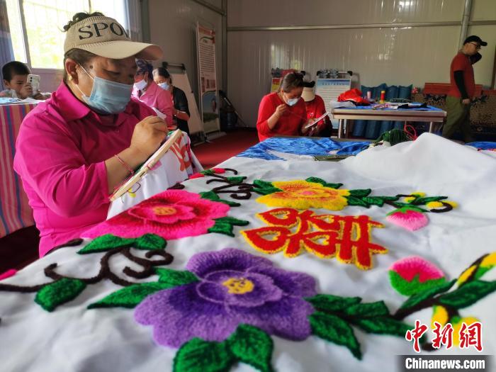 圖為婦女制作青繡?！?zhí)砀?攝