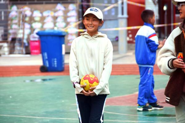 在高原上教孩子們打手球，“慢慢兒來，甭著急！”