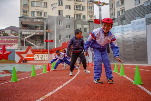 在高原上教孩子們打手球，“慢慢兒來，甭著急！”