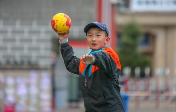 在高原上教孩子們打手球，“慢慢兒來，甭著急！”