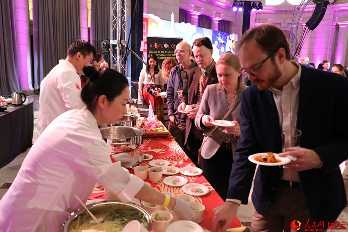 當(dāng)?shù)貢r(shí)間3月7日晚，華盛頓聯(lián)合車(chē)站廣場(chǎng)舉行駐美使團(tuán)“使館主廚挑戰(zhàn)賽”。圖為當(dāng)?shù)孛癖娫谥袊?guó)展臺(tái)前體驗(yàn)中國(guó)美食。人民網(wǎng)記者 李志偉攝