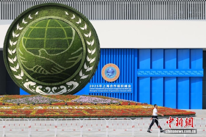 8月31日，天津，一名工作人員從2025年上海合作組織峰會(huì)主會(huì)場外的景觀花壇旁經(jīng)過。當(dāng)日，2025年上海合作組織峰會(huì)在天津舉行。<a target='_blank' href='/'><p  align=