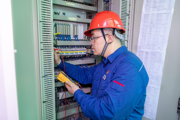 呂曉勇在保護(hù)盤柜前檢查二次回路接線情況。受訪者供圖