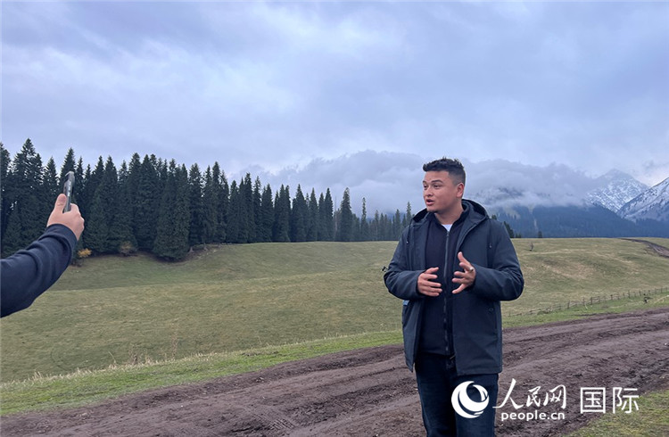 在庫爾德寧，吾買爾江被雪山美景震撼，即興錄制了短視頻作品。人民網(wǎng)記者曾書柔攝