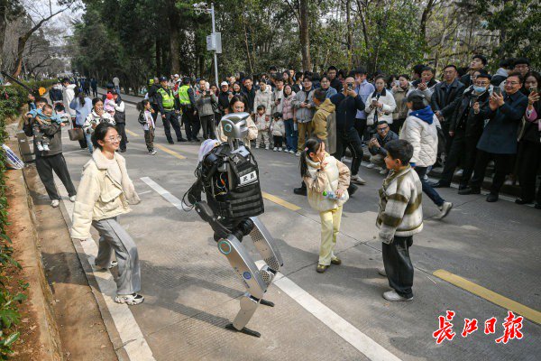 “智警小珞”人形機(jī)器人和小朋友們斗舞。長江日報(bào)記者史偉 攝