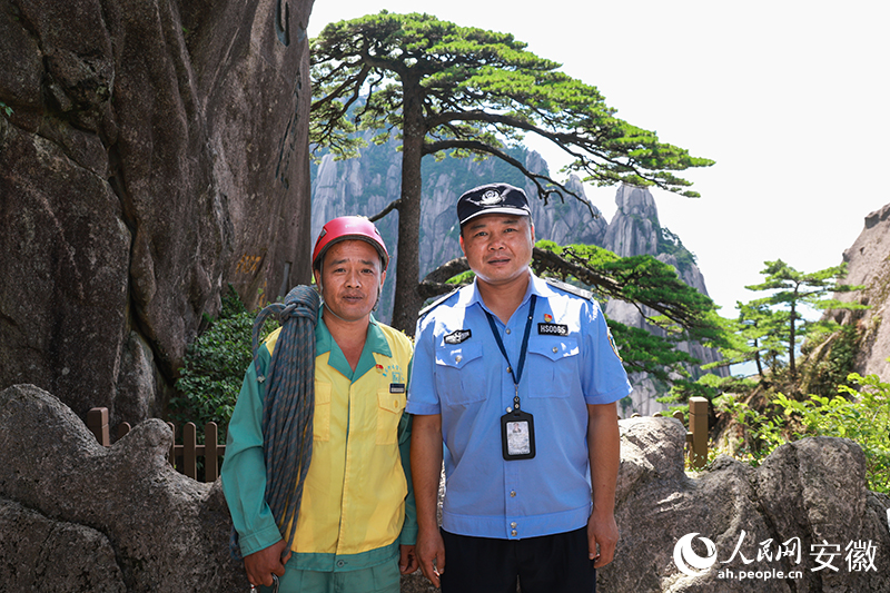 全國道德模范李培生（左）和胡曉春在迎客松前合影。人民網(wǎng)記者 張俊攝
