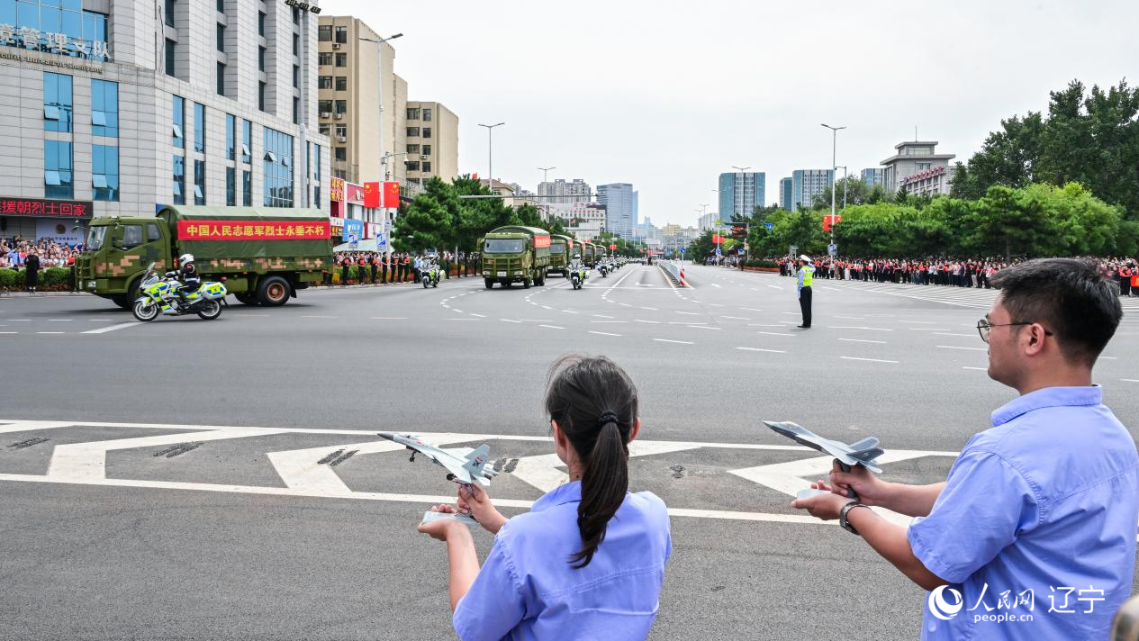 航空工業(yè)沈飛的青年技術(shù)人員拿著受閱戰(zhàn)機的模型迎接烈士遺骸。航空工業(yè)沈飛供圖