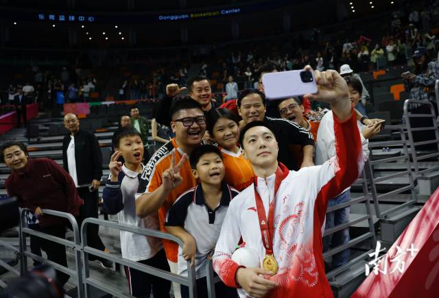 11月12日，十五運會男籃成年組決賽，廣東隊獲得冠軍后，胡明軒與球迷們合影留念。張由瓊 攝