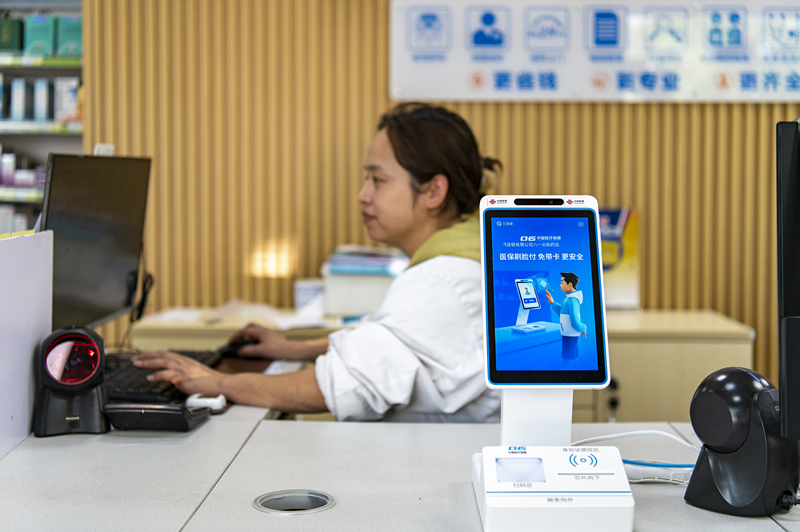 2024年4月10日，浙江金華市區(qū)一家民眾大藥房柜臺(tái)上設(shè)置著醫(yī)?！八⒛樦Ц丁睓C(jī)器，群眾看病更加便利。