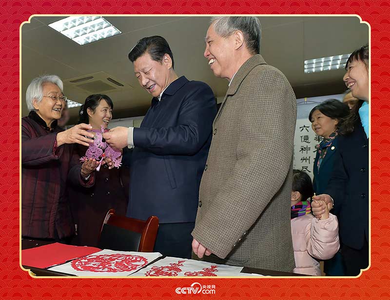 2015年2月15日，習近平在西安市雁塔區(qū)電子城街道二〇五所社區(qū)服務中心欣賞社區(qū)居民的剪紙作品。