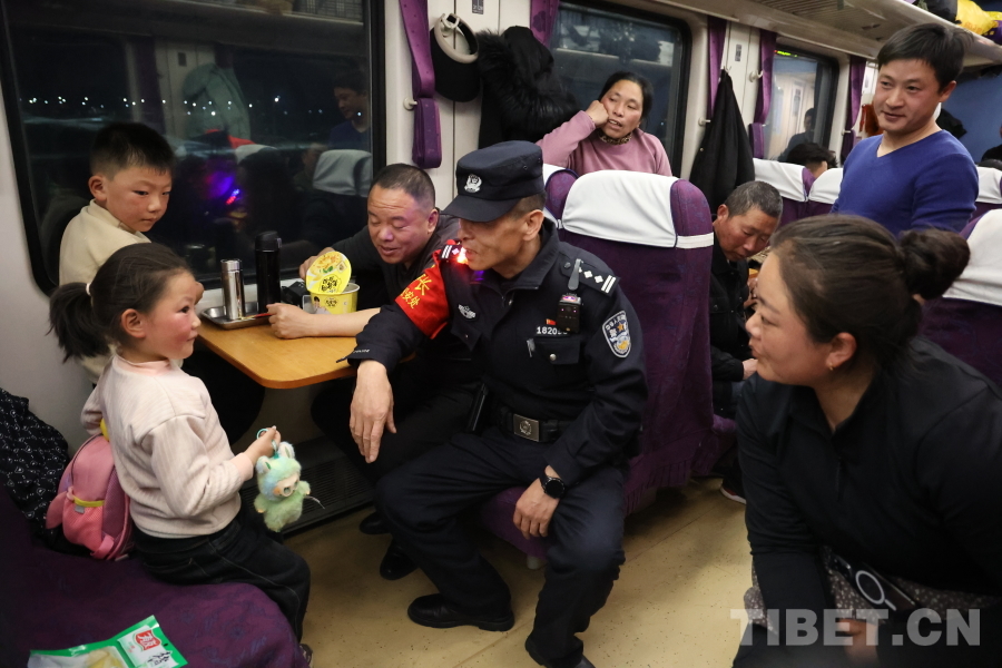 乘警長左紅彬在巡視車廂間隙，向攜帶兒童的旅客專門叮囑安全注意事項。.JPG