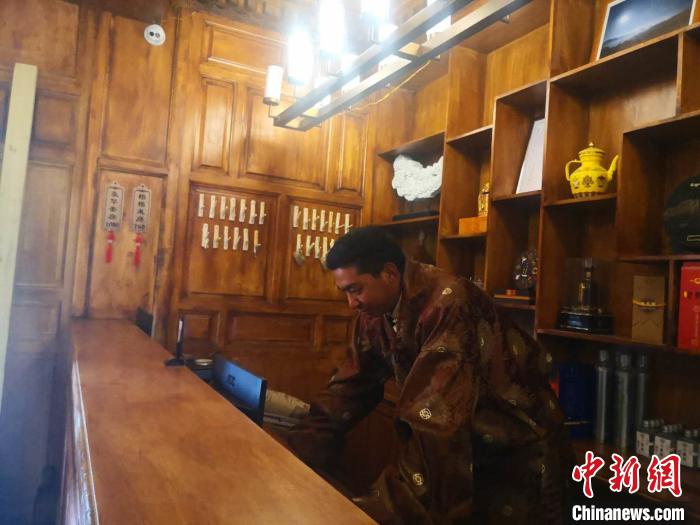 圖為桑杰才讓用電腦處理財務?！∈缝o靜 攝