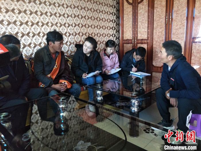 圖為調(diào)查組工作人員正在入戶調(diào)查。　祁增蓓 攝