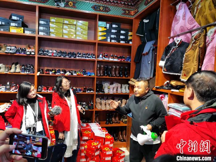 圖為中外媒體在玉樹州玉樹市甘達(dá)村采訪?！?zhí)砀?攝