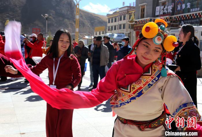 圖為中外記者向當?shù)孛癖妼W習民族歌舞文化?！?zhí)砀?攝
