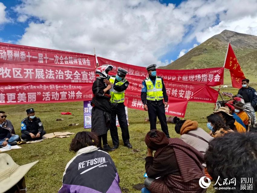 給牧民講如何佩戴安全頭盔。巴登攝