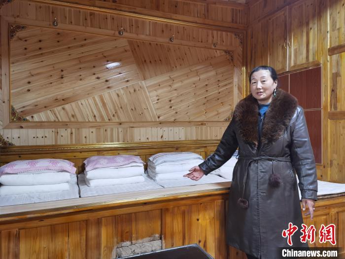 圖為德吉村村民鬧尖措介紹自家農(nóng)家樂?！∑钤鲚?攝