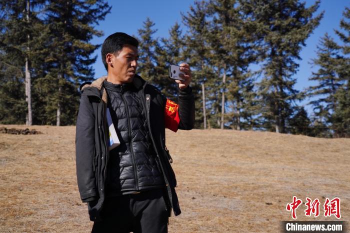 圖為桑杰加進行巡查并拍照記錄?！●R銘言 攝