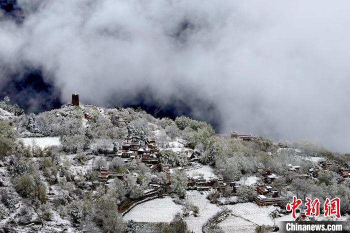 雪后的藏寨和碉樓構(gòu)成美麗的雪景?！〗党鯘衫?攝