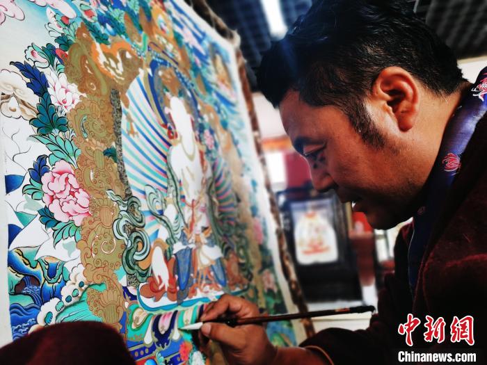 圖為久美尖措創(chuàng)作唐卡。　張?zhí)砀?攝