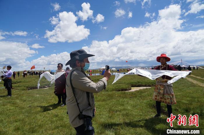 圖為一名外籍?dāng)z影師記錄當(dāng)?shù)夭刈鍤g迎儀式?！●R銘言 攝