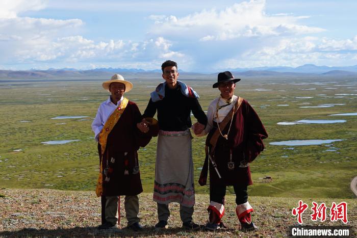 圖為一名留學(xué)生身穿自己國(guó)家的服飾和藏族民眾合影留念?！●R銘言 攝