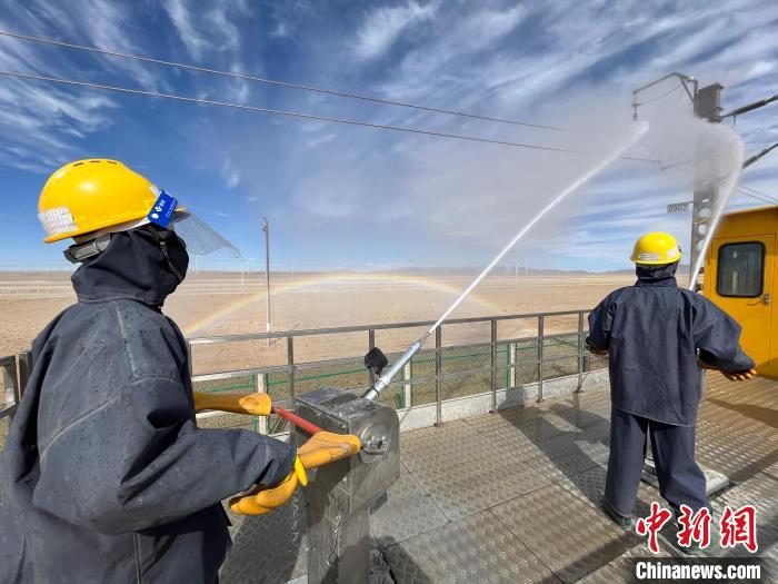 圖為水炮手操作高壓水槍對(duì)絕緣子進(jìn)行清洗。　高啟宏 攝