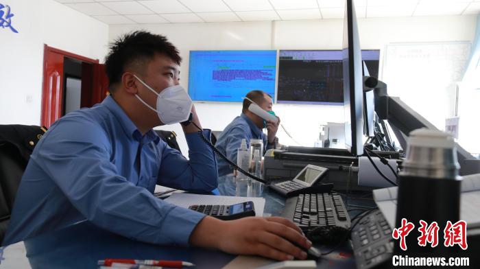 圖為貨運(yùn)調(diào)度人員與外勤工作人員聯(lián)系掌握車輛裝載情況?！±钌?攝