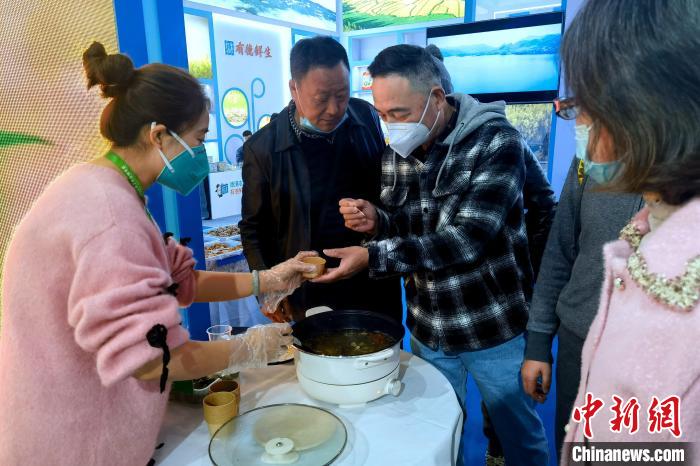 圖為杭州市民品嘗茶卡羊肉?！±铍h 攝