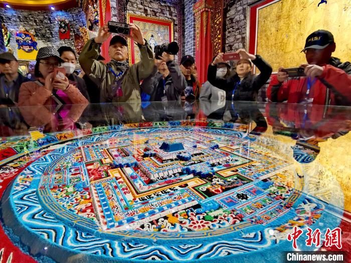 圖為參觀者拍攝壇城?！?zhí)砀?攝