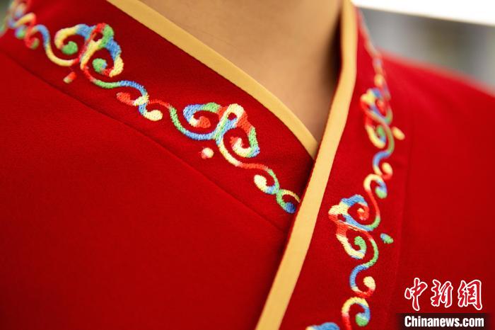 圖為新制服領(lǐng)口點綴有蒙古特色的烏力吉紋繡花?！±罾?攝