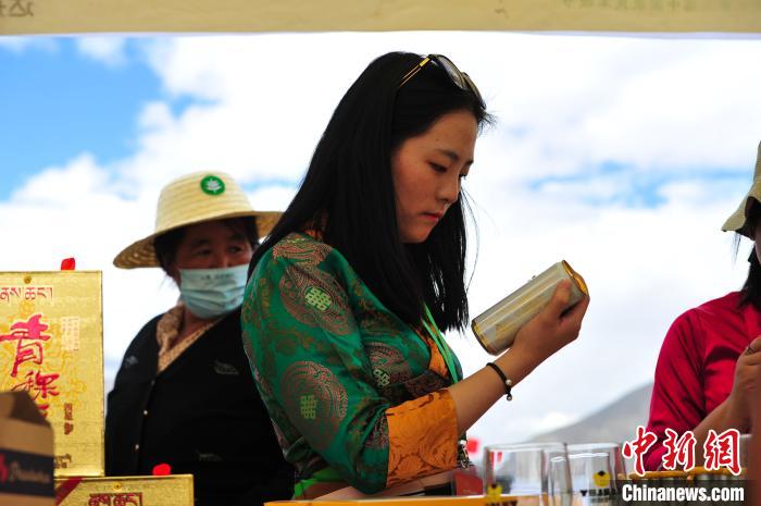 圖為拉薩市民在特色農(nóng)畜產(chǎn)品展示展銷會上選購商品?！垈?攝