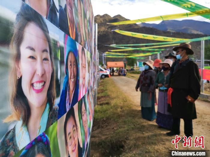 圖為當?shù)孛癖娫谟^看展板上的笑臉。　張偉 攝