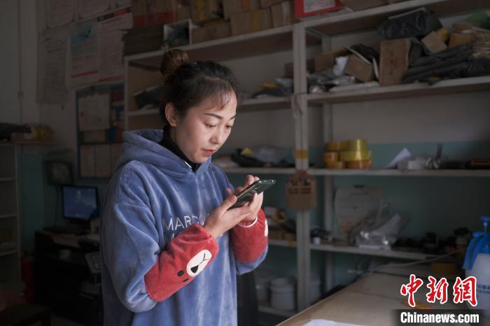 正在快遞站點內(nèi)忙碌的楊莉春?！『闻罾?攝