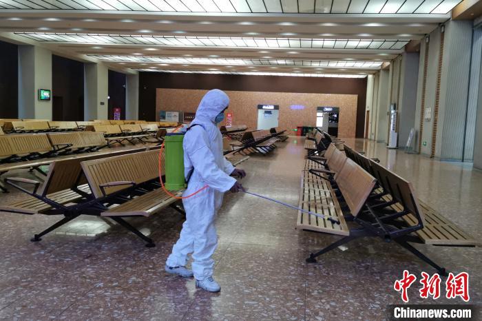 圖為拉薩車站工作人員在候車室進(jìn)行消毒。　李海星 攝