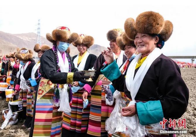 資料圖：西藏自治區(qū)拉薩市曲水縣才納鄉(xiāng)協(xié)榮村參加春耕儀式的村民互敬青稞酒。按照傳統(tǒng)，當(dāng)?shù)卮迕裆碇?jié)日盛裝，舉行隆重的儀式，祈福一年的豐收。<a target='_blank' ><p  align=