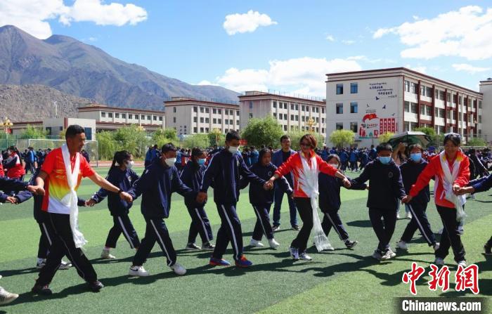 圖為世界冠軍與拉薩阿里地區(qū)高級(jí)中學(xué)學(xué)生一起跳鍋莊。　冉文娟 攝