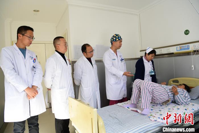 圖為何蔚副主任醫(yī)師(站右二)及團隊術后指導患者進行腰背肌鍛煉?！∝暩聛硭?攝