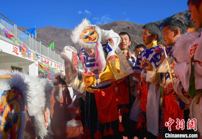 圖為加查縣安繞鎮(zhèn)小學學生在試穿藏戲面具?！∝暩聛硭?攝