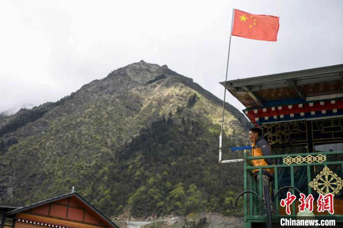 村民站在樓房上觀望?！钊A峰 攝