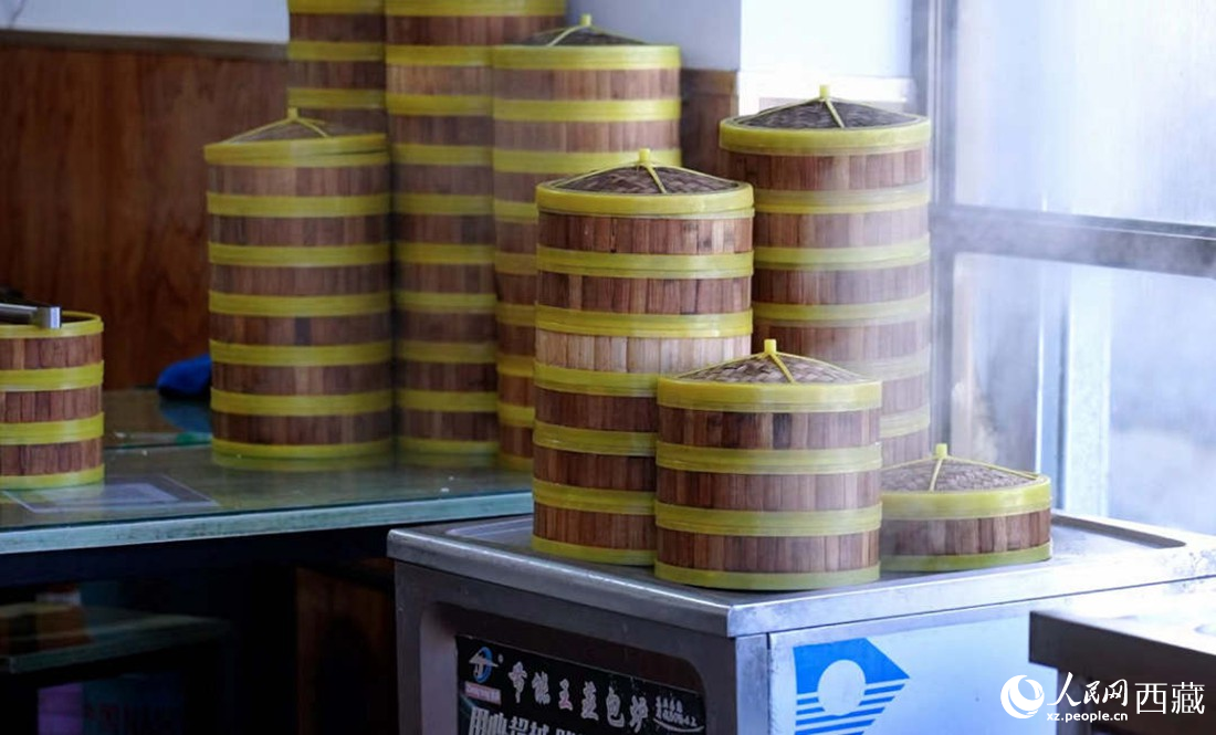 電蒸箱上擺滿了多屜熱氣騰騰的包子。人民網(wǎng) 次仁羅布攝