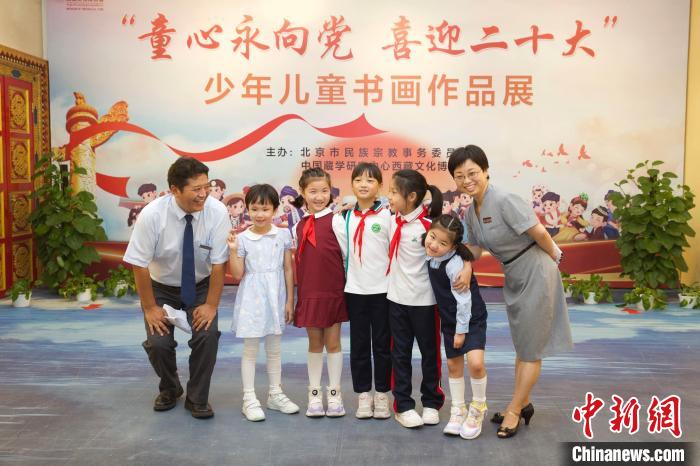 圖為與會(huì)嘉賓與入選畫(huà)作的“小作者”們?cè)谡褂[上合影?！≈袊?guó)藏學(xué)研究中心供圖