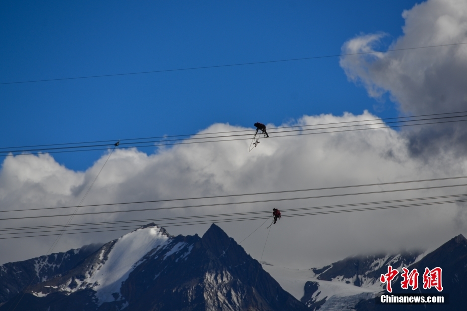 資料圖為2020年6月23日，西藏阿里聯(lián)網(wǎng)工程施工人員在日喀則希夏邦馬雪山附近進(jìn)行走線作業(yè)，安裝絕緣設(shè)備。 <a target='_blank' href='/'><p  align=