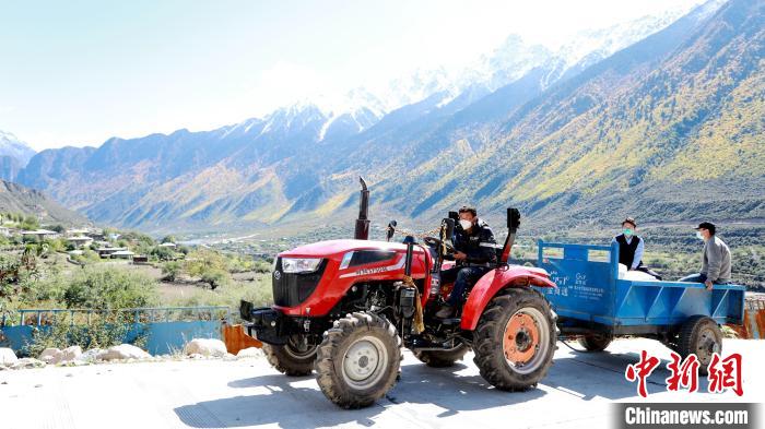 圖為工作人員將把加工完成的糌粑運(yùn)送至村民手中。　嘉黎縣融媒體中心供圖