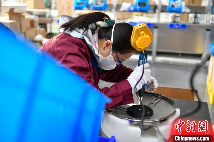 圖為工人正在組裝炊具。　貢嘎來松 攝